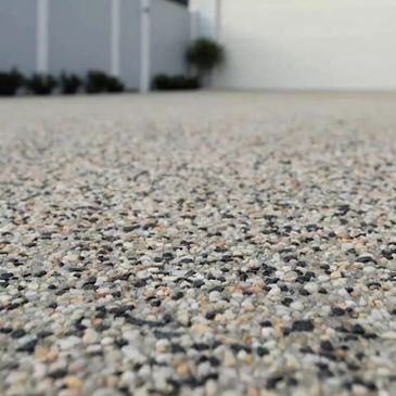 Close-up view of a textured outdoor surface made of small, mixed-color stones.