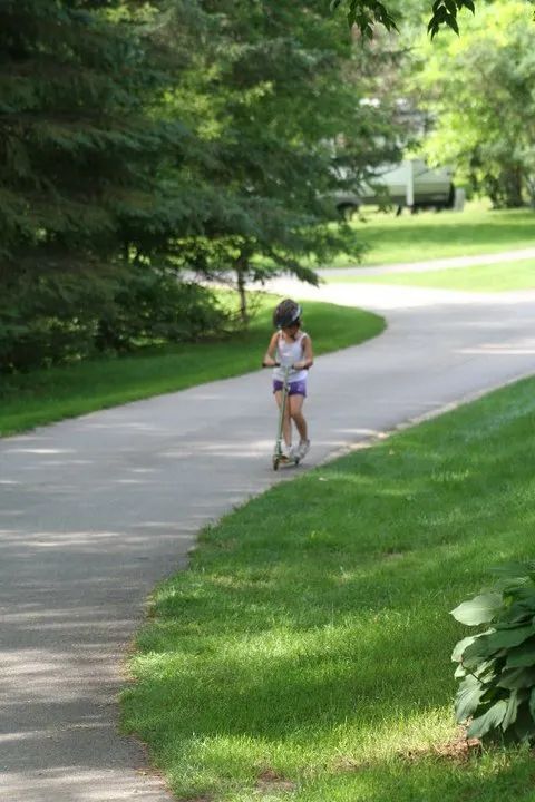 Child Playing with Scooter — Wilton, WI — Tunnel Trail Campground