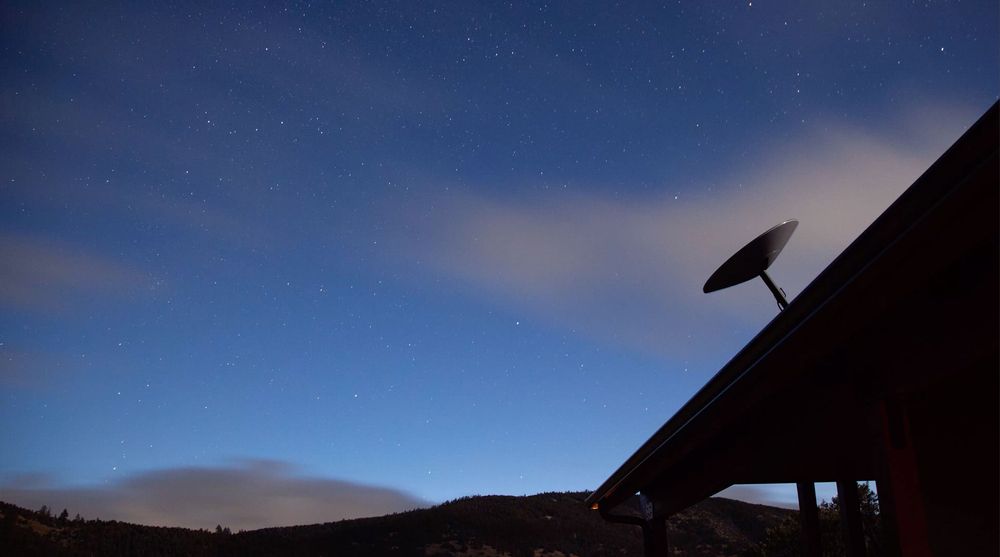 A Satellite Dish On The Roof Of A House At Night — Bradshaws Radio & TV Service In Hervey Bay, QLD