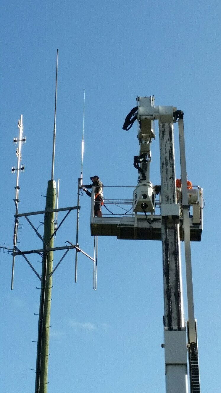 A Man In A Bucket Is Working On A Telephone Pole — Bradshaws Radio & TV Service In Maryborough, QLD