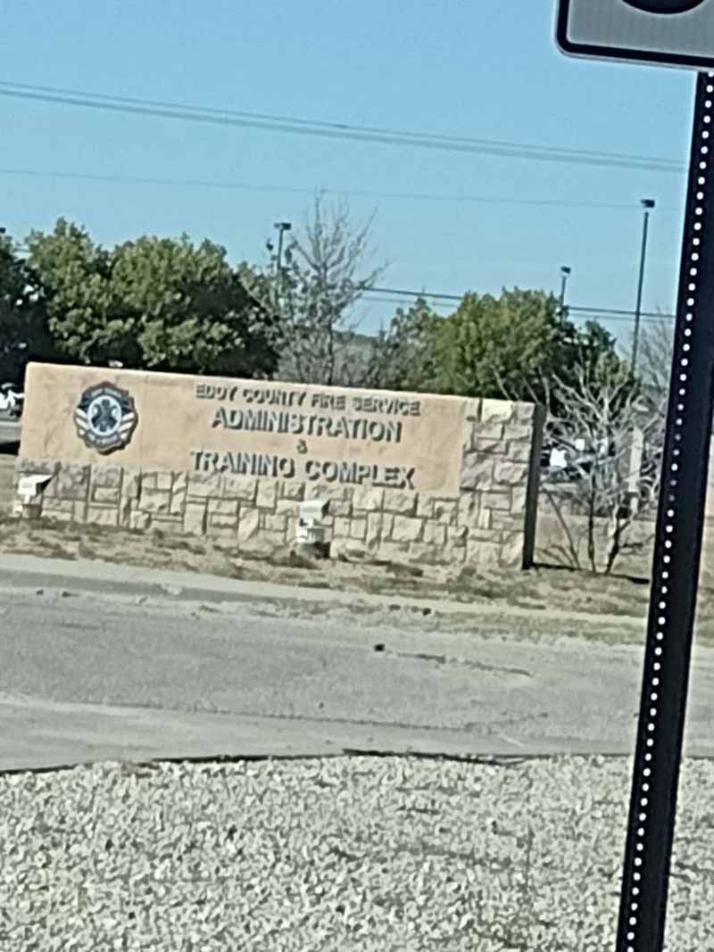 Sign for New Braunfels Fire and Rescue Administration & Training Complex. Beige stone with a blue emblem.