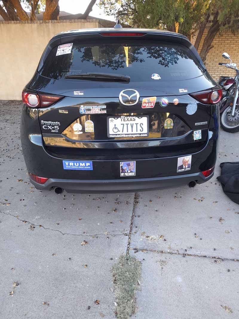 A black Mazda SUV with various stickers, including a 