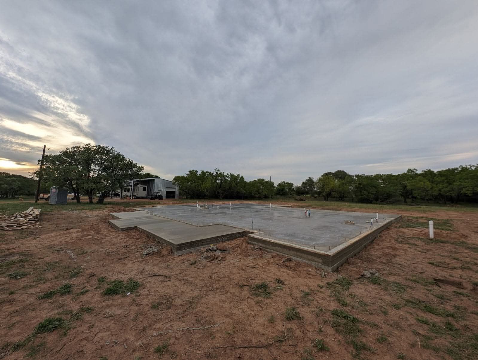 Reinforced concrete foundation with steel rebar framework against a blue sky.