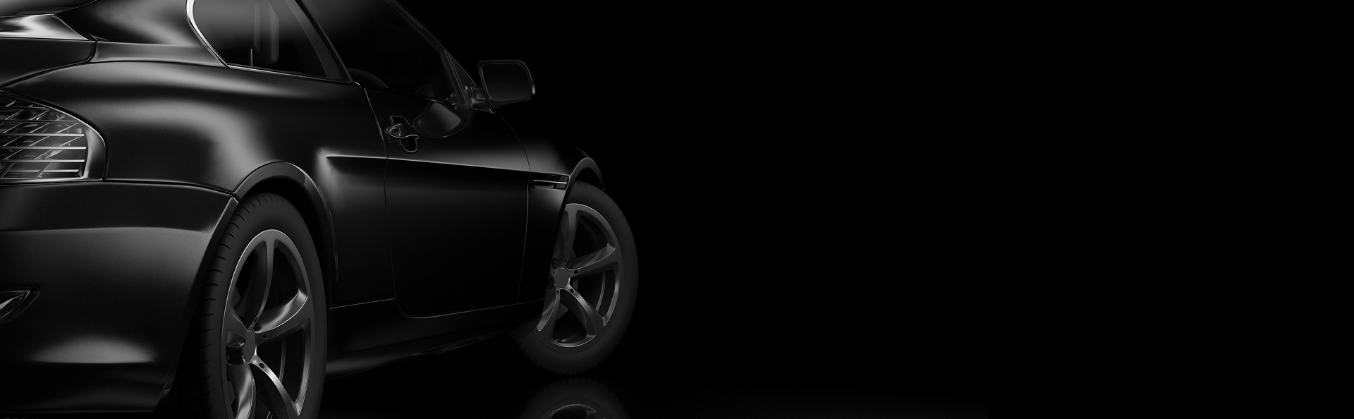 Black sports car with silver rims, angled, on a dark reflective surface | J & J Elite Auto Repair