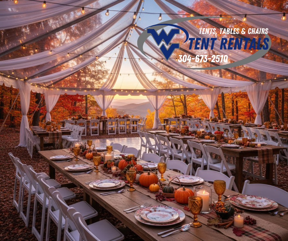 A large white tent surrounded by fall foliage with tables set for Thanksgiving dinner.