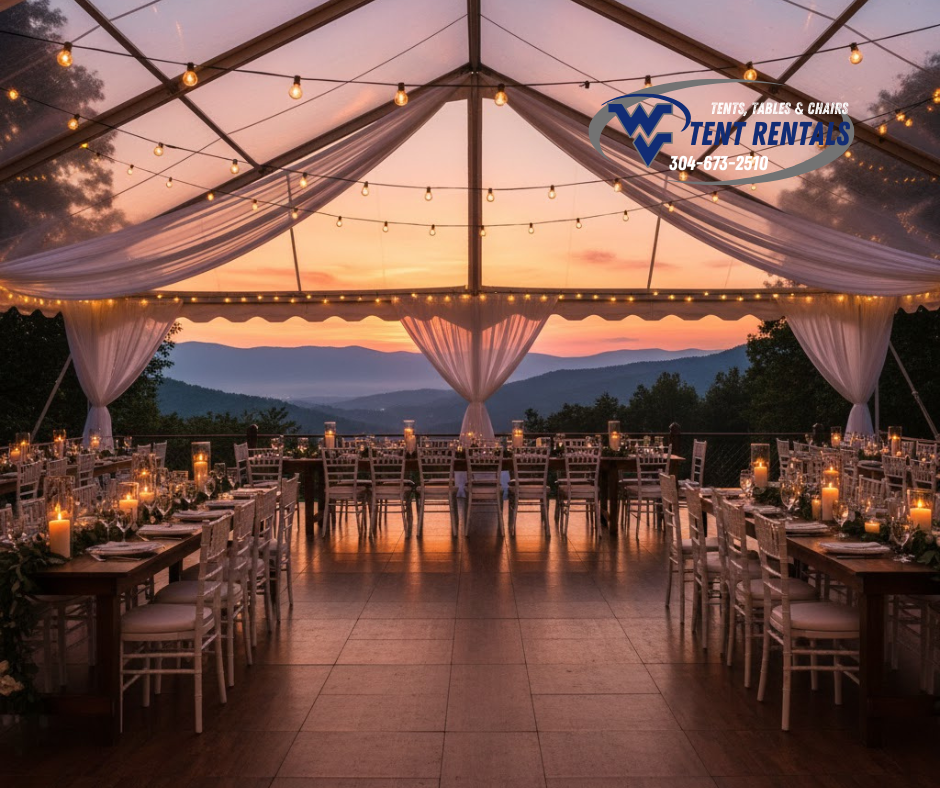 A romantic white wedding tent glowing with bistro lights against a West Virginia mountain sunset.