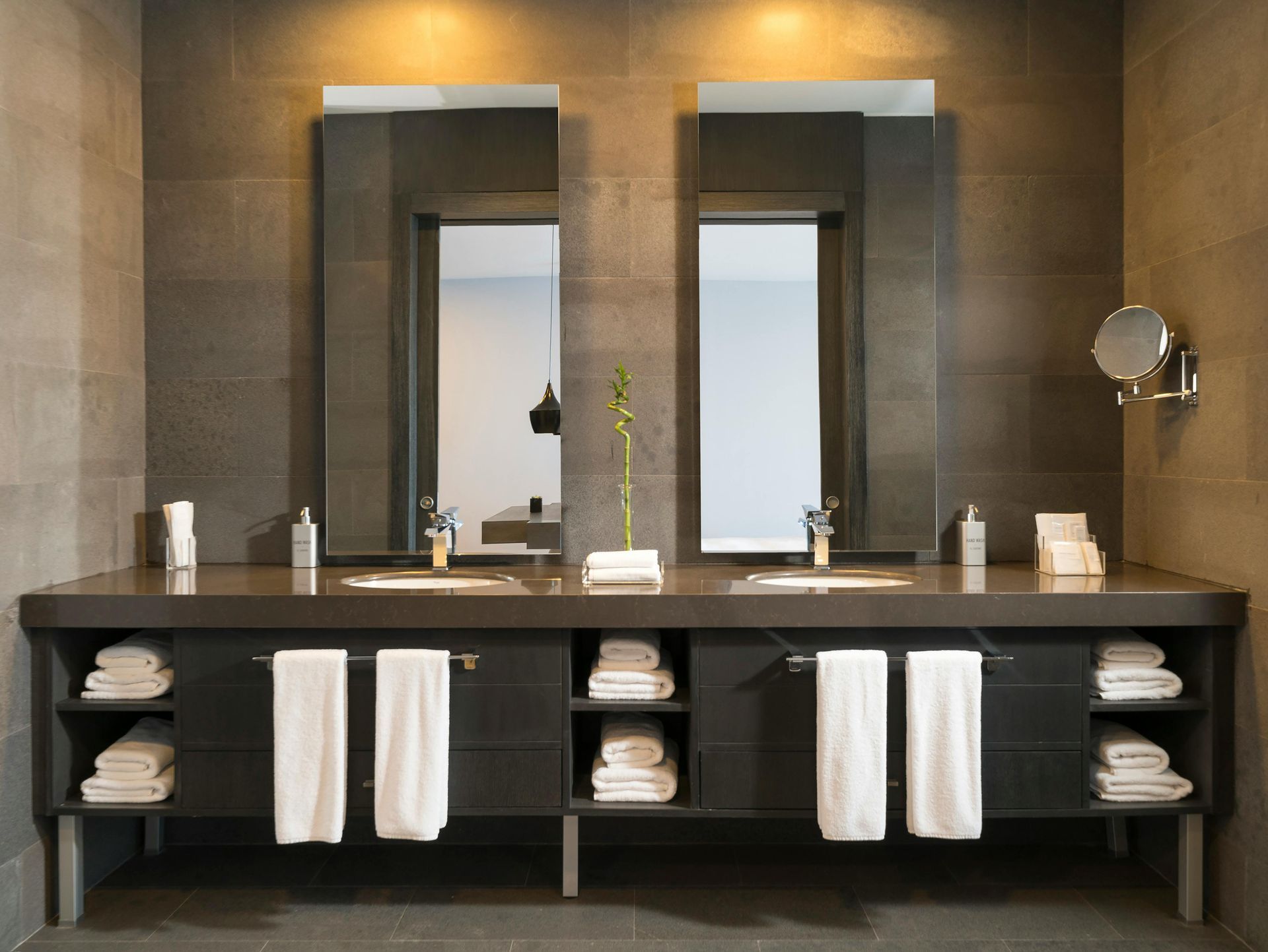 Modern bathroom with a double sink vanity, two mirrors, and gray tile.