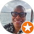 Person with glasses smiles on a boat, ocean background, star icon.