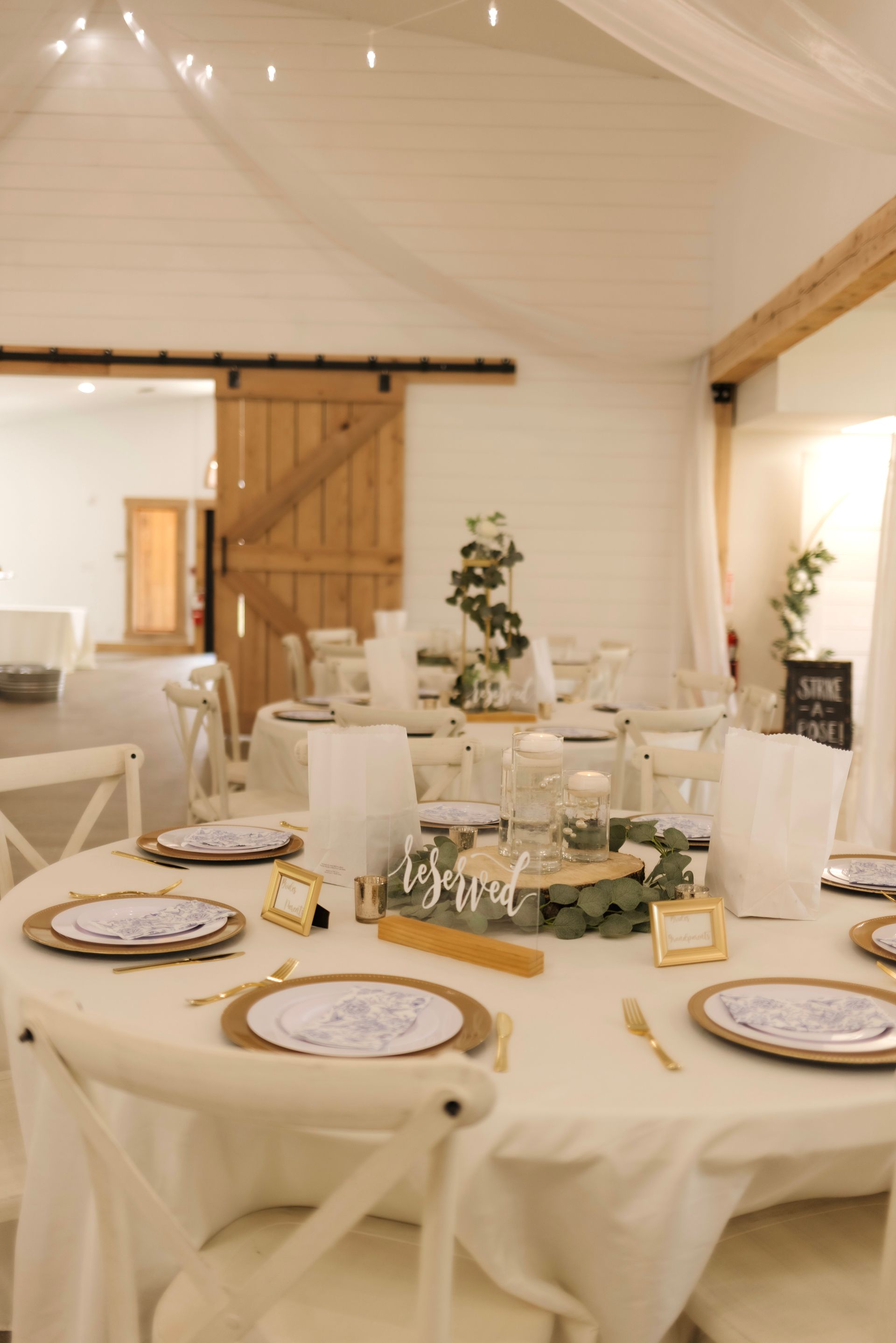 A room with tables and chairs set up for a wedding reception.