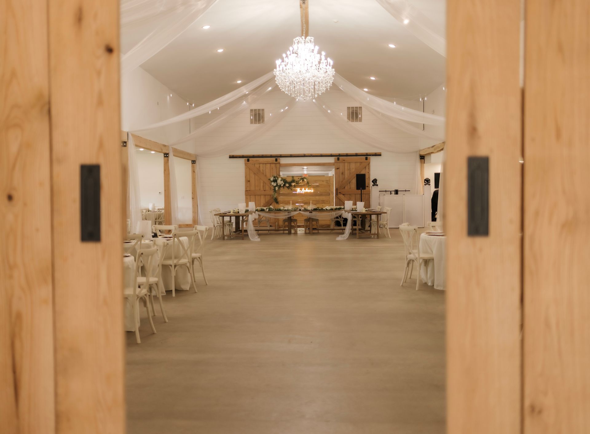 A large room with tables and chairs and a chandelier.