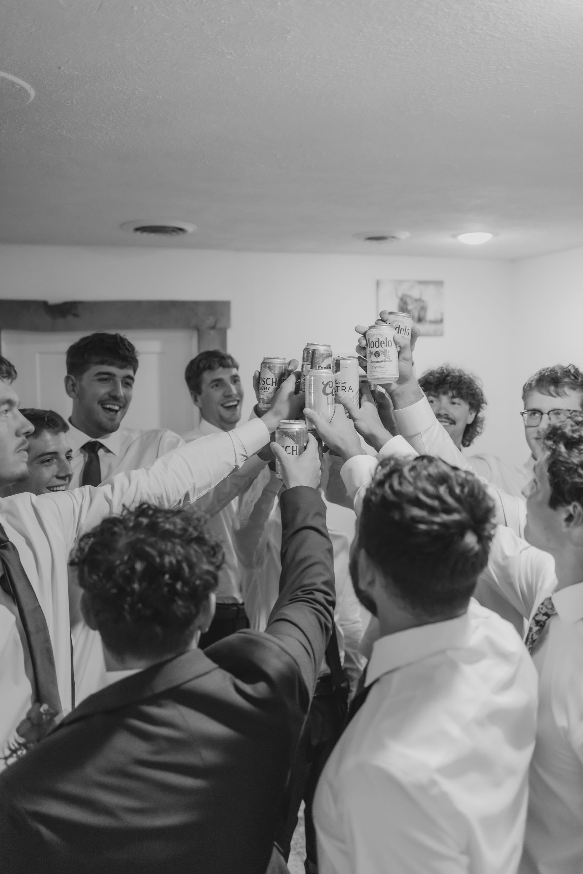 A group of men are toasting with beer in a black and white photo.