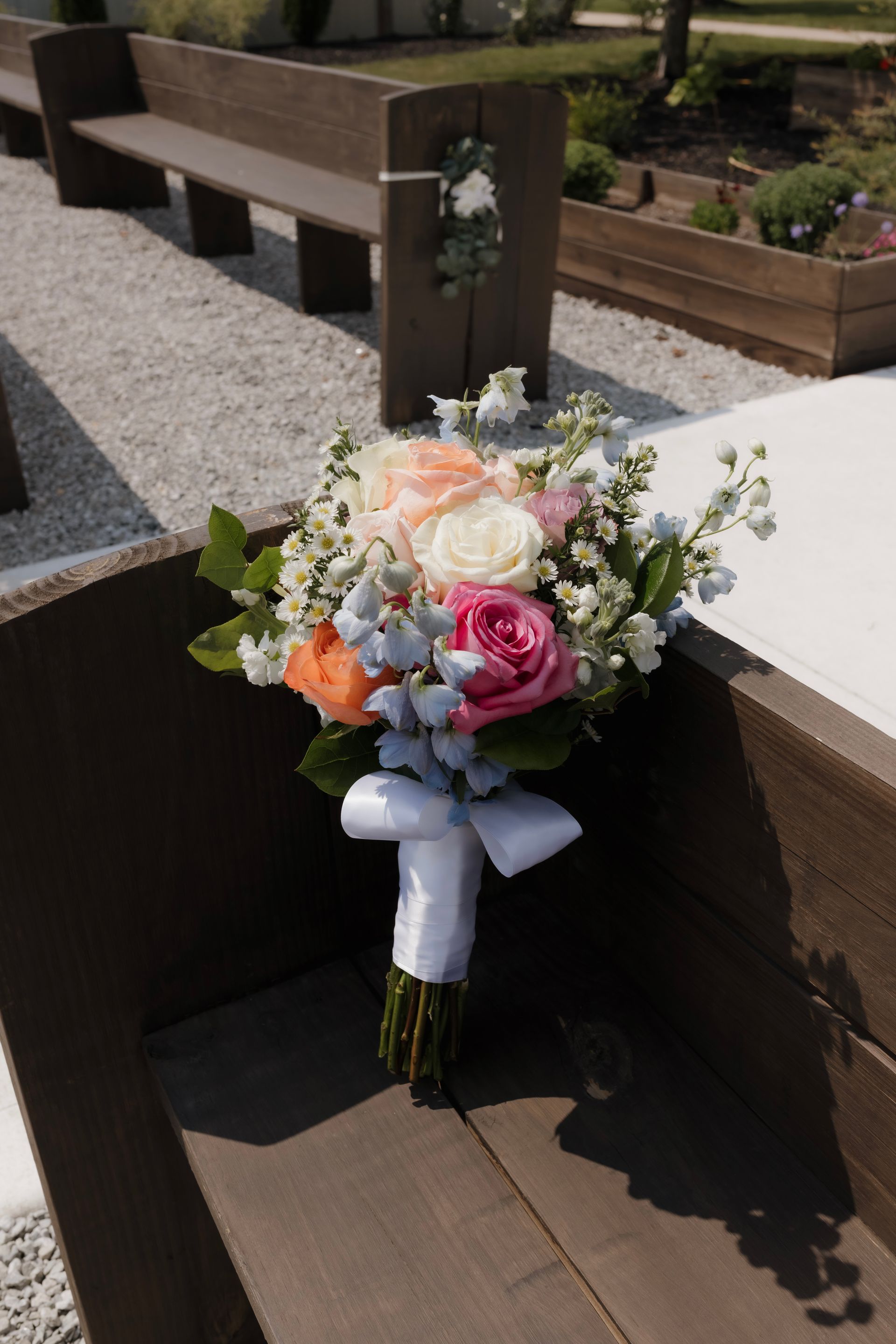A bouquet of flowers is sitting on a wooden bench.