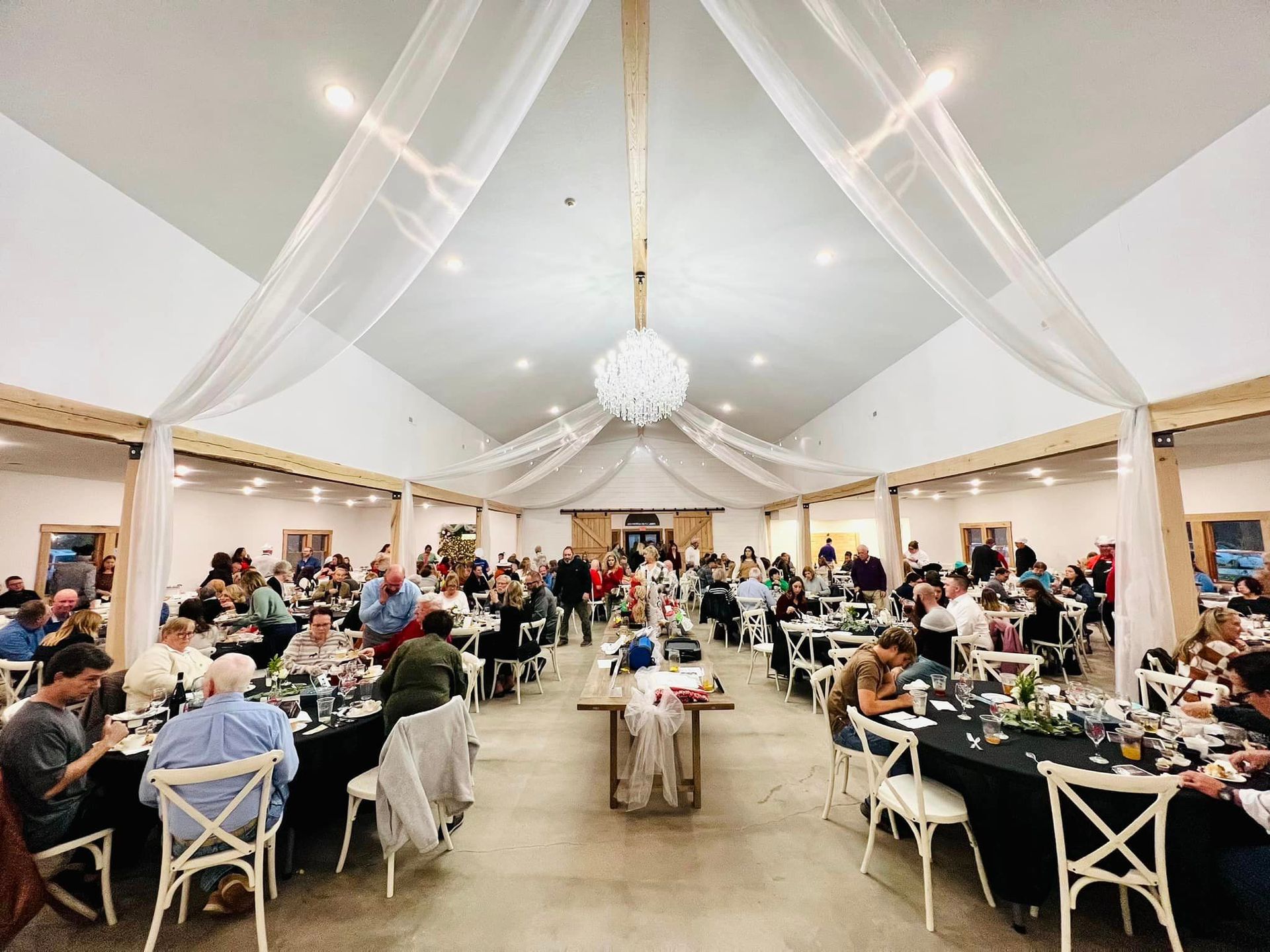 A large room filled with people sitting at tables and chairs.