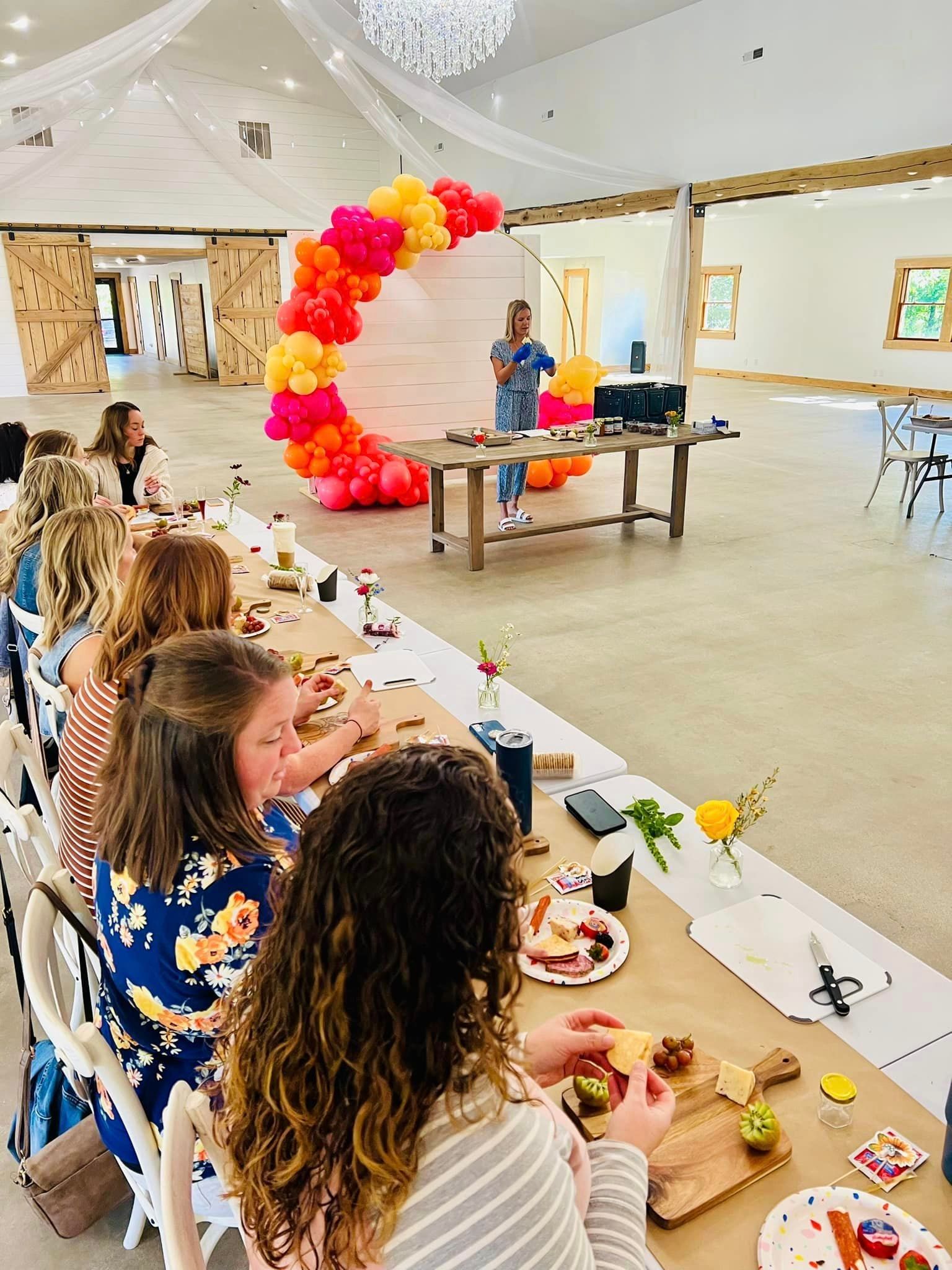 A group of women are sitting at a long table eating food.