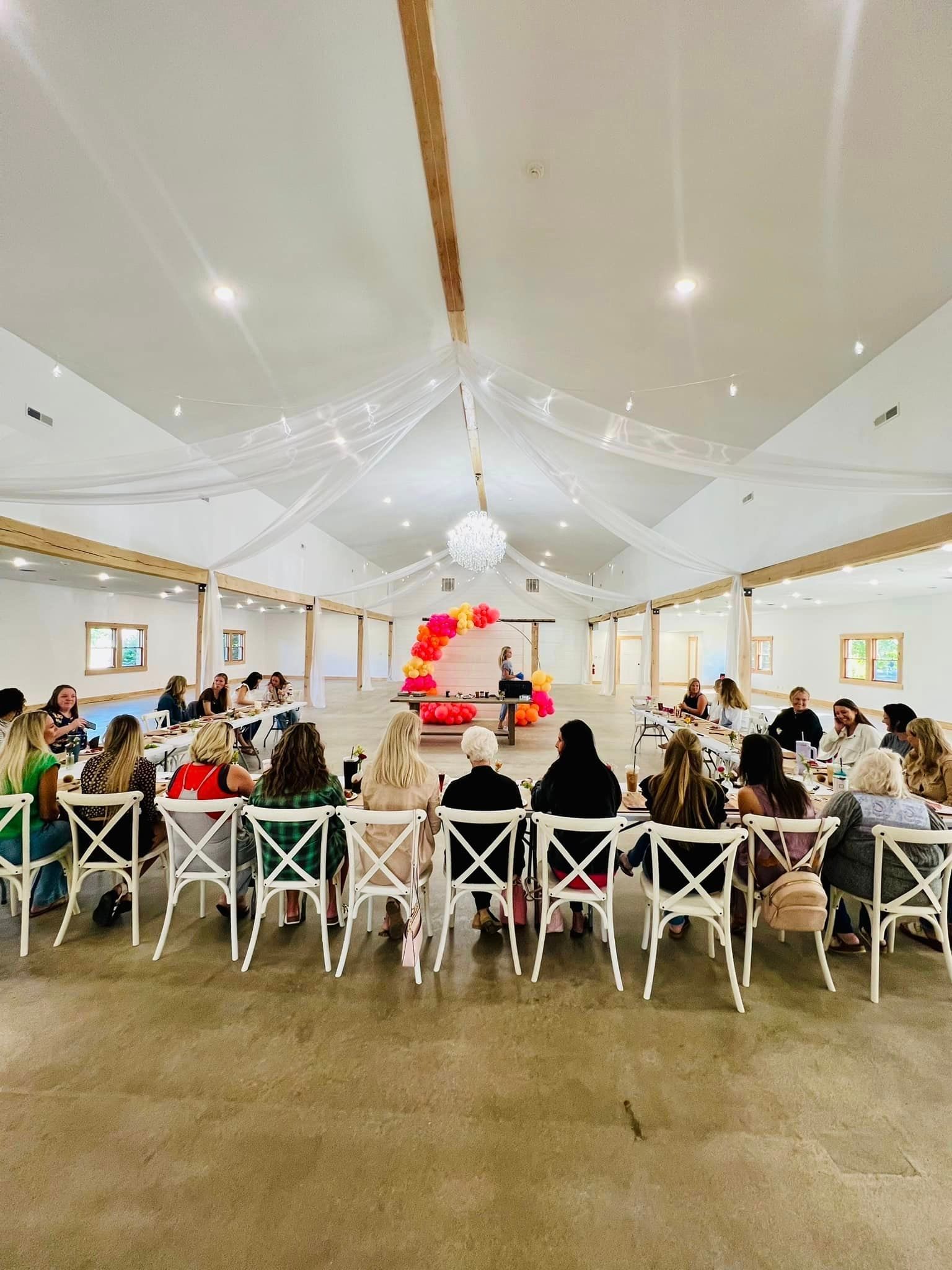 A group of people are sitting at tables in a large room.