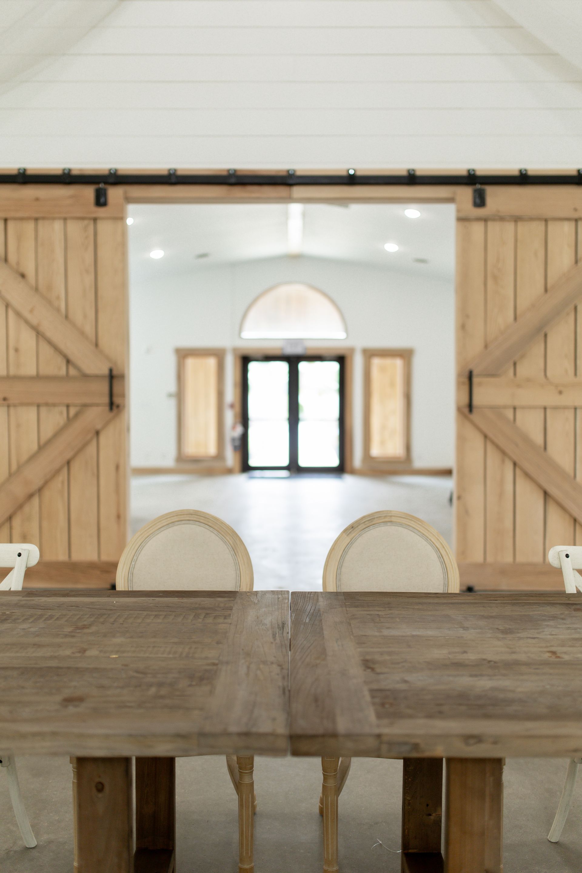 A wooden table and chairs in a room with sliding barn doors.