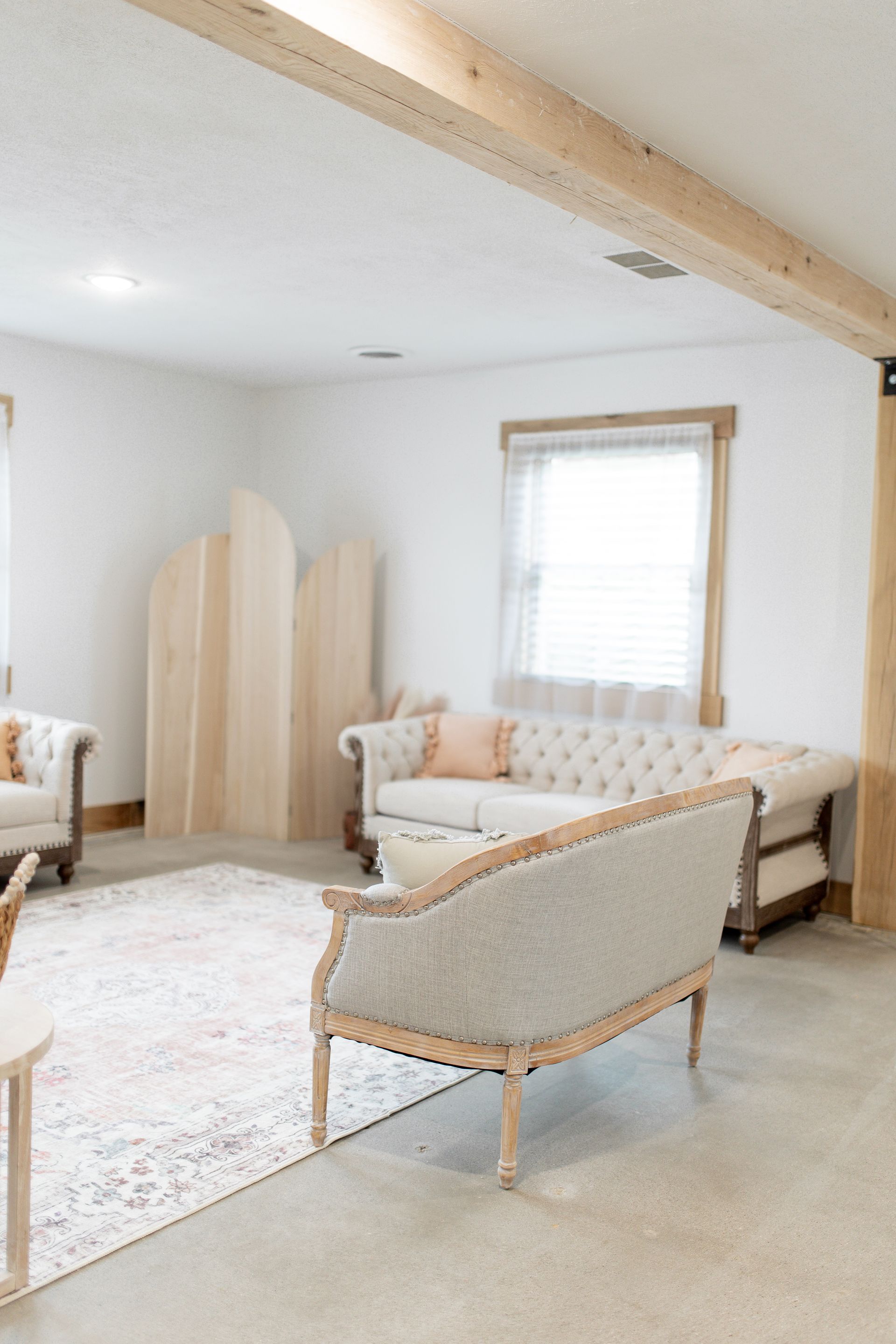 A living room with a couch , chairs , and a rug.