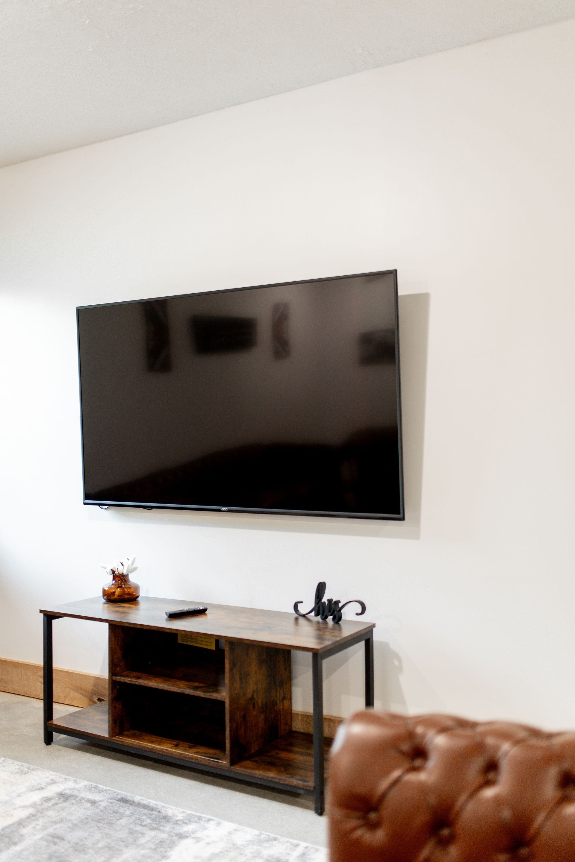 A living room with a flat screen tv mounted on the wall.