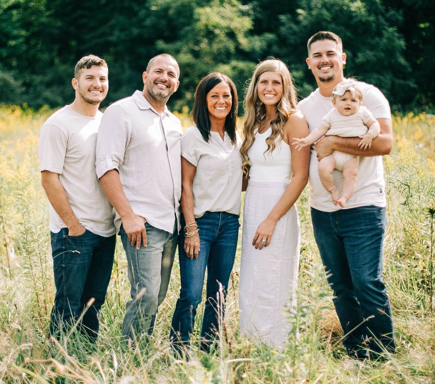 A group of people are posing for a picture in a field.