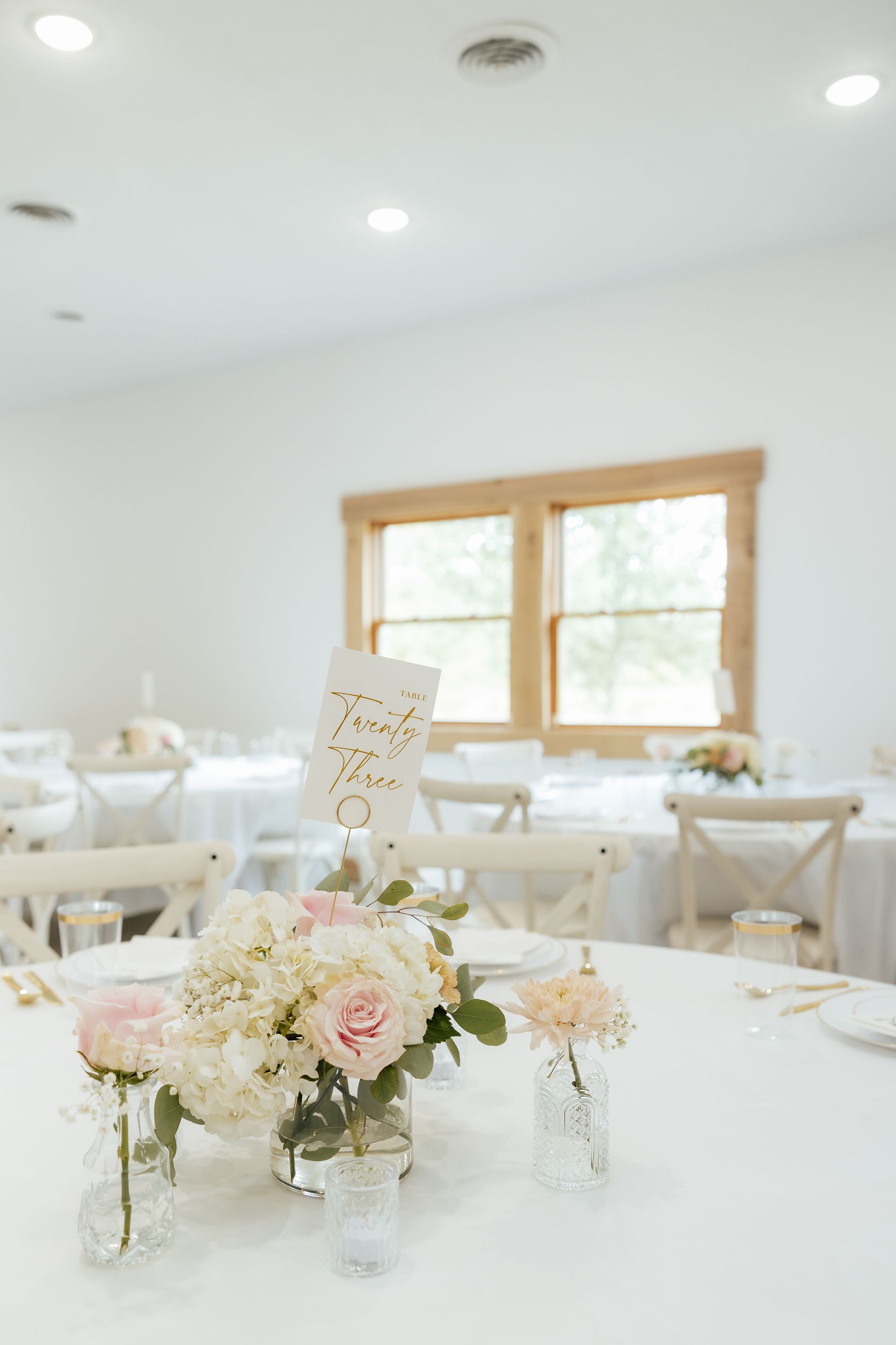 A table with a vase of flowers and a table number on it.