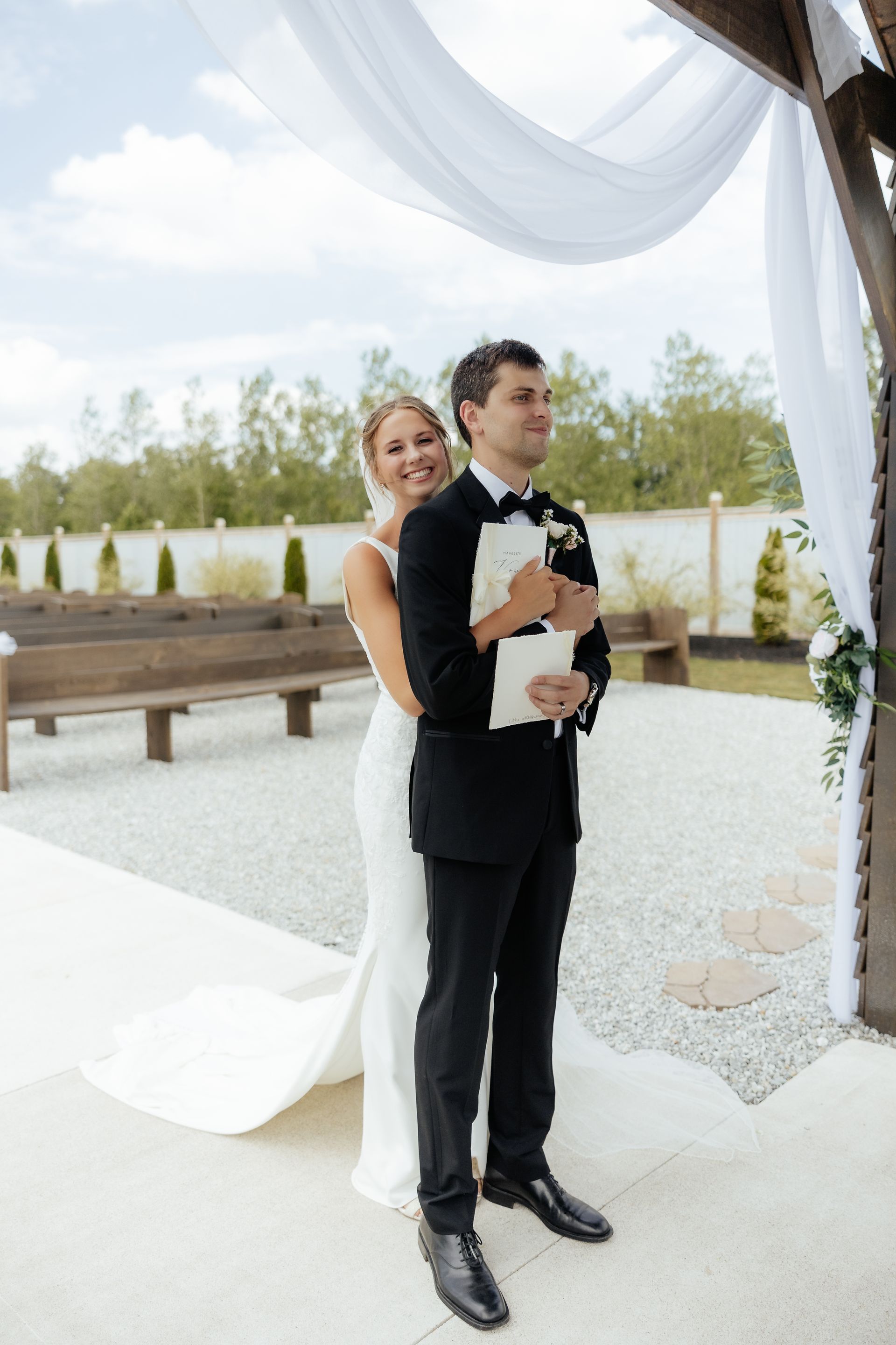 A bride and groom are standing under a canopy at their wedding.