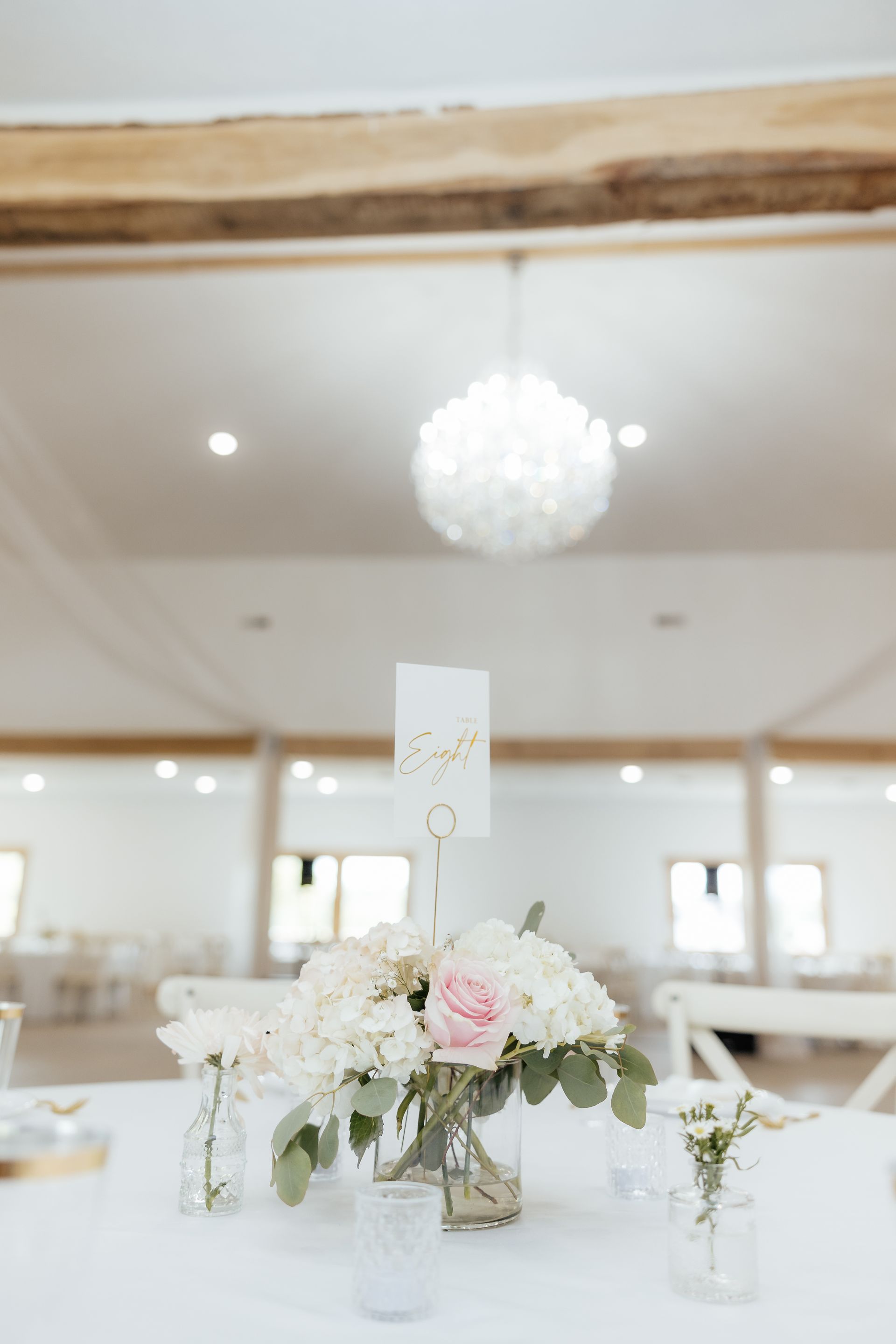 A table with a vase of flowers and a table number on it.