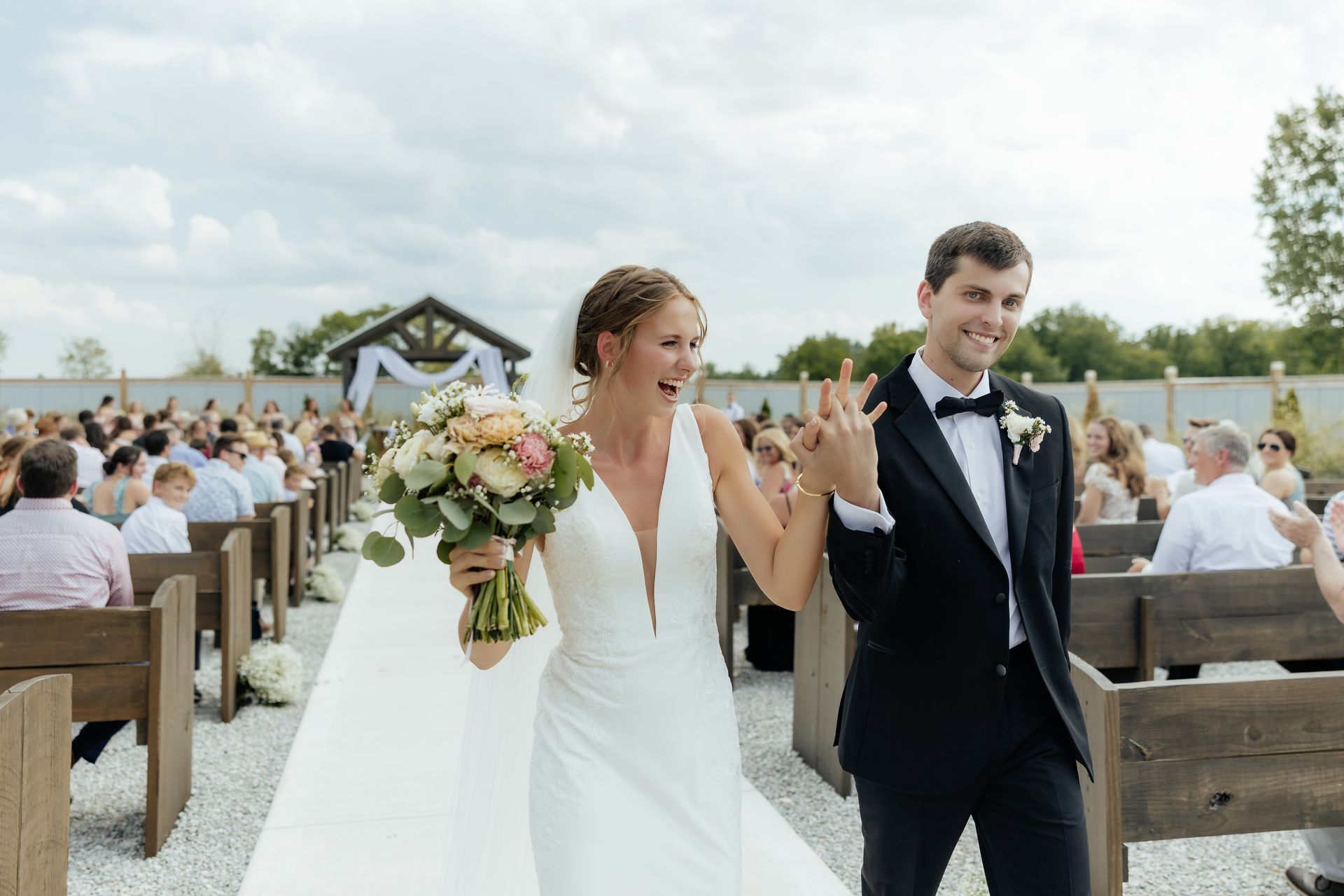 A bride and groom are walking down the aisle at their wedding.