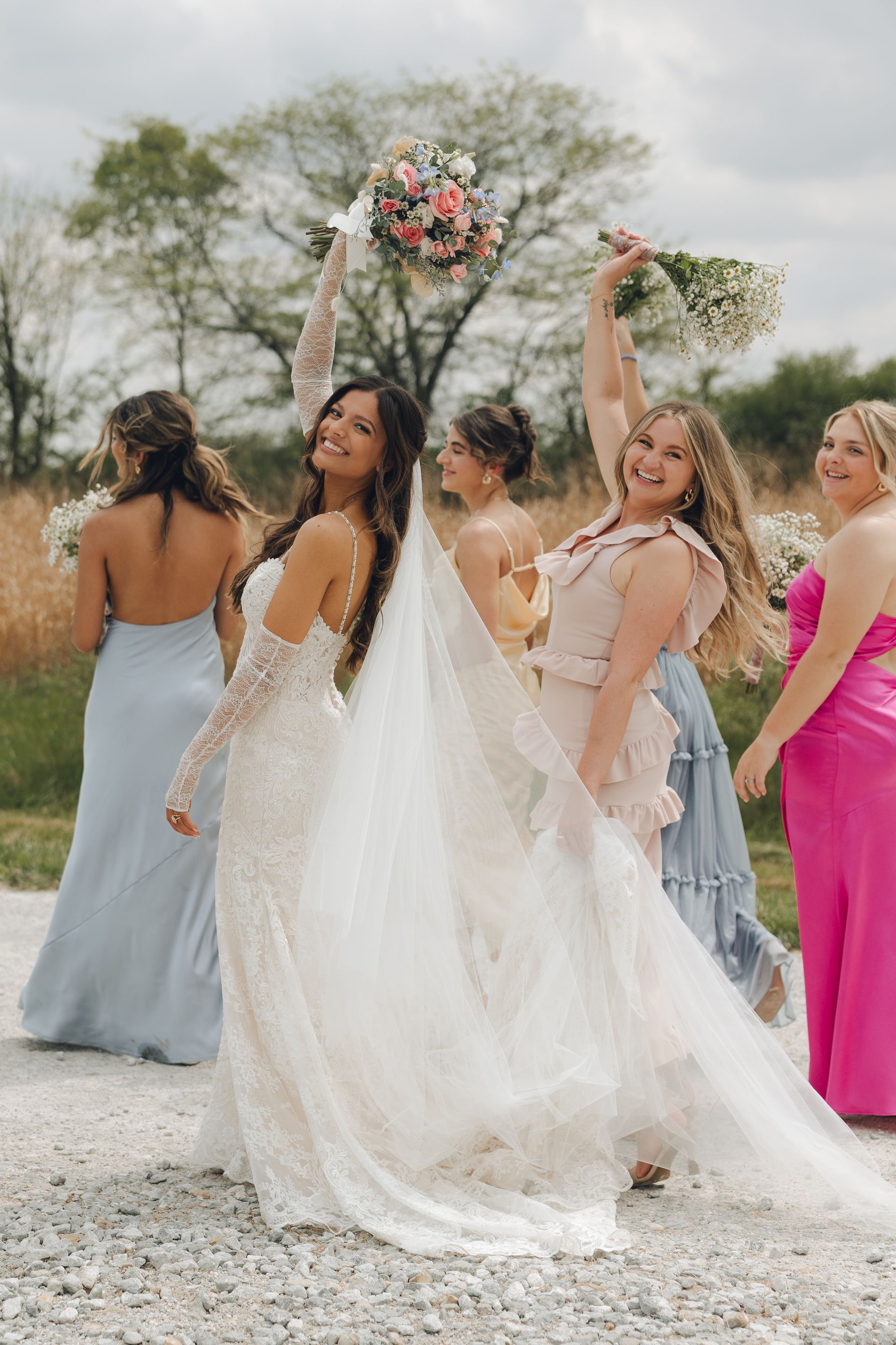 A bride and her bridesmaids are posing for a picture.