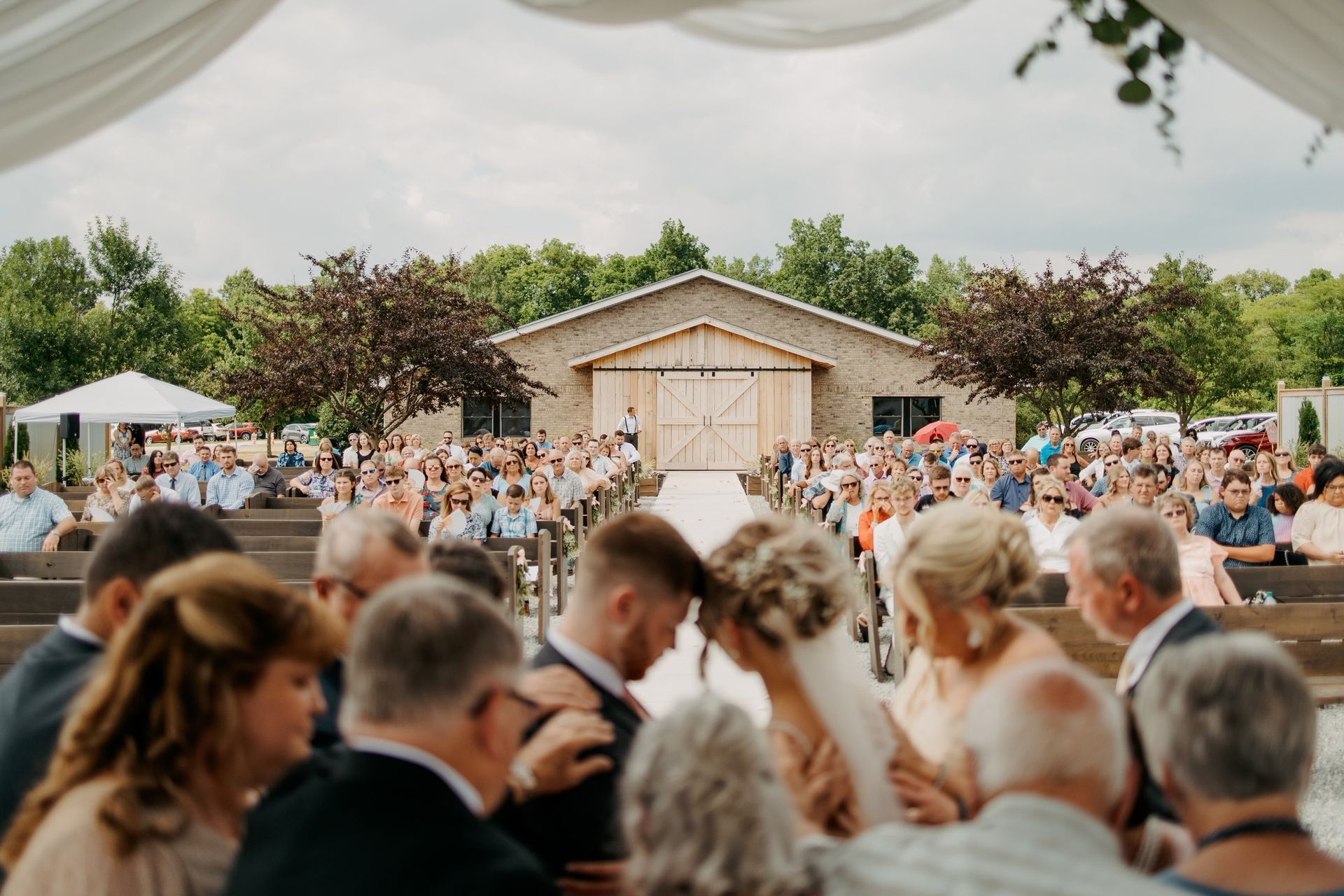 A bride and groom are getting married in front of a large crowd of people.