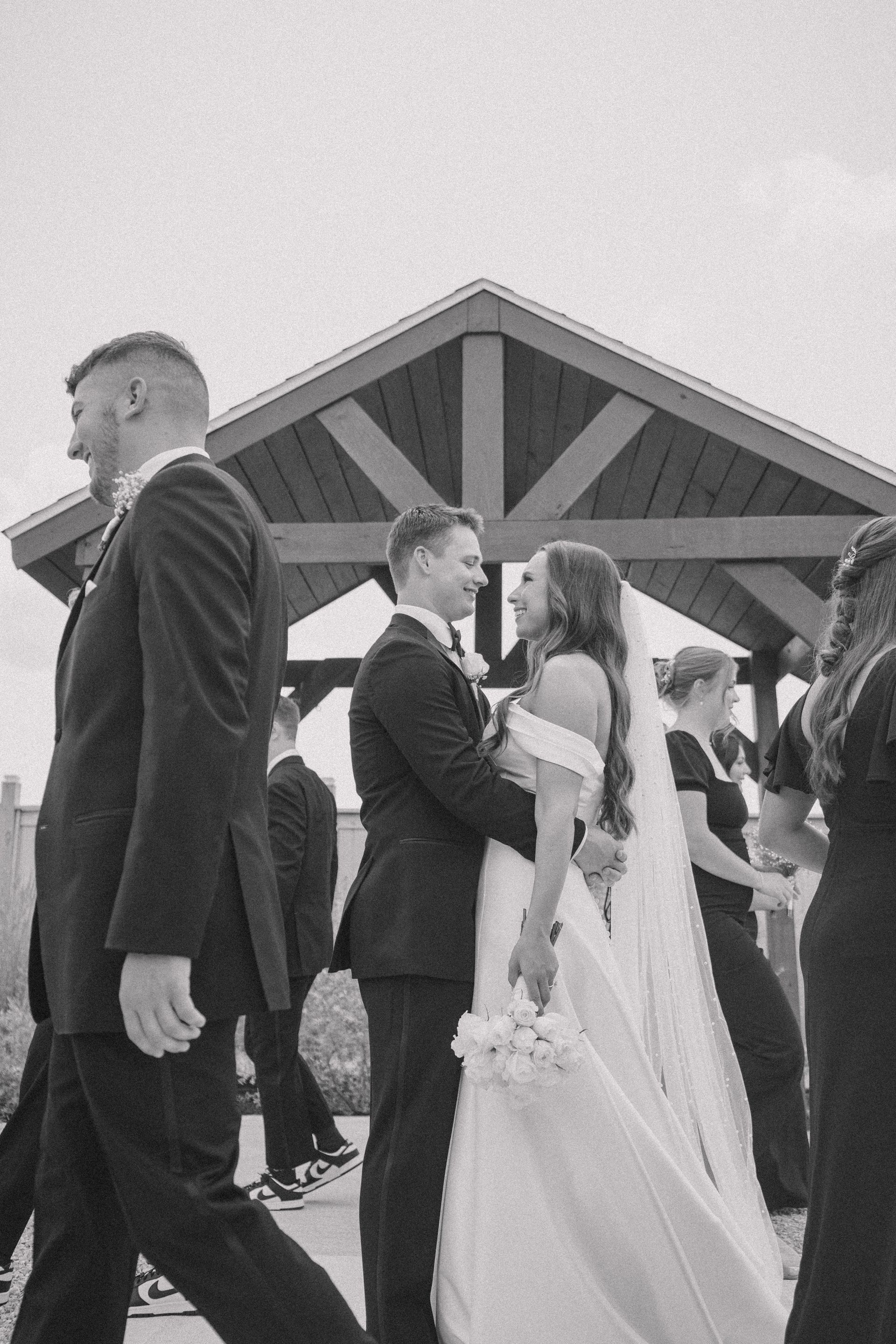 A black and white photo of a bride and groom walking down the aisle.