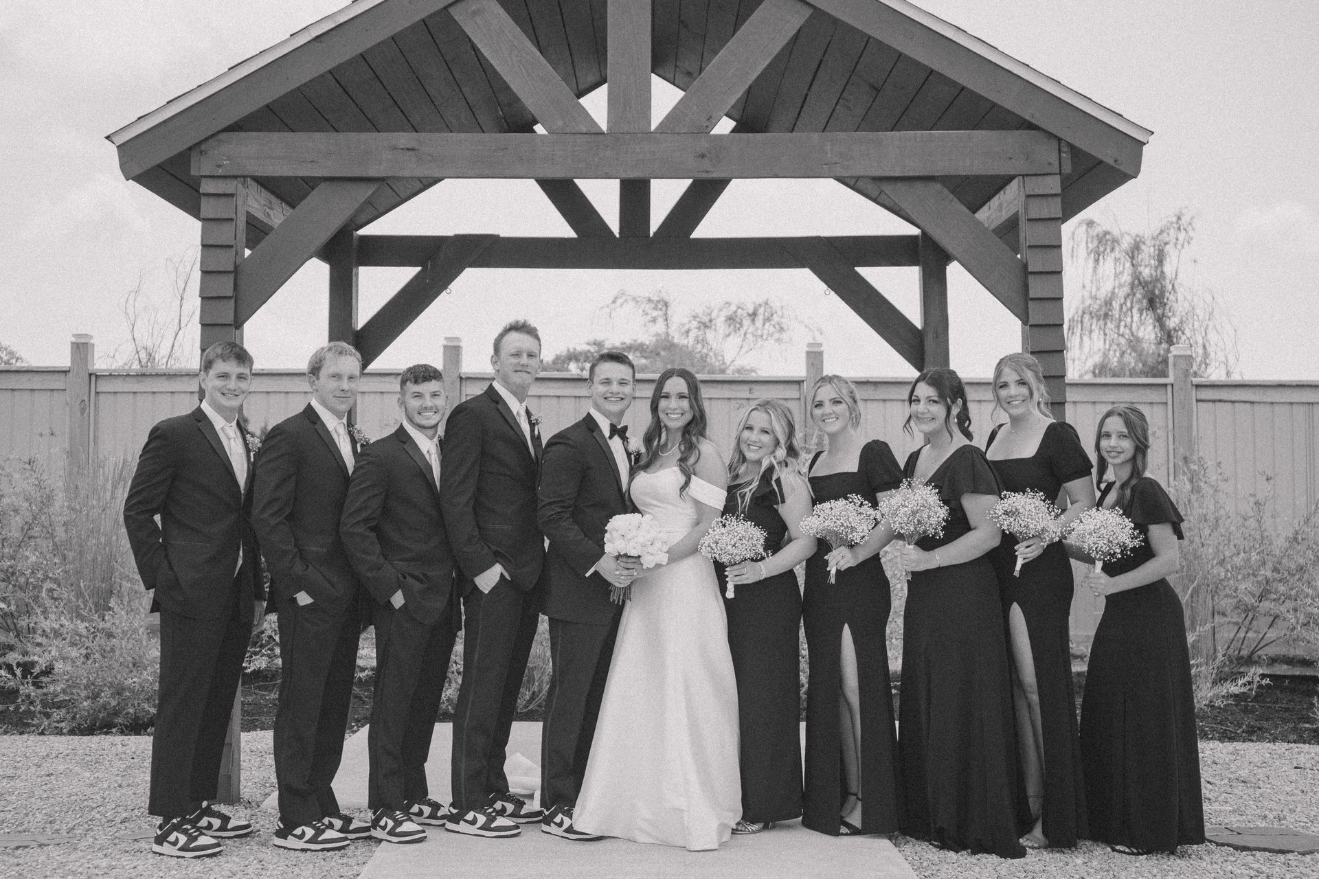 A black and white photo of a bride and groom and their wedding party