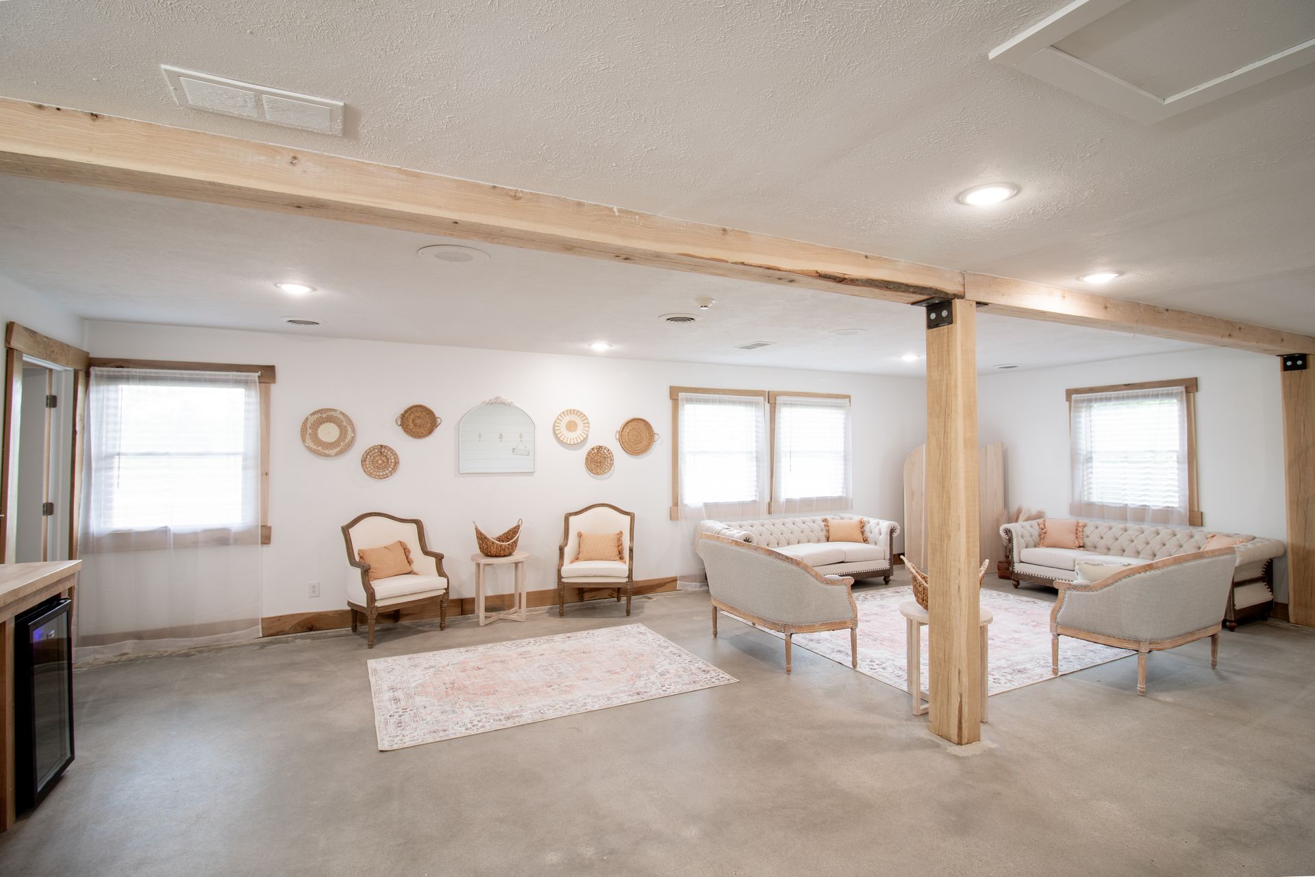 A living room with a couch , chairs , and a rug.