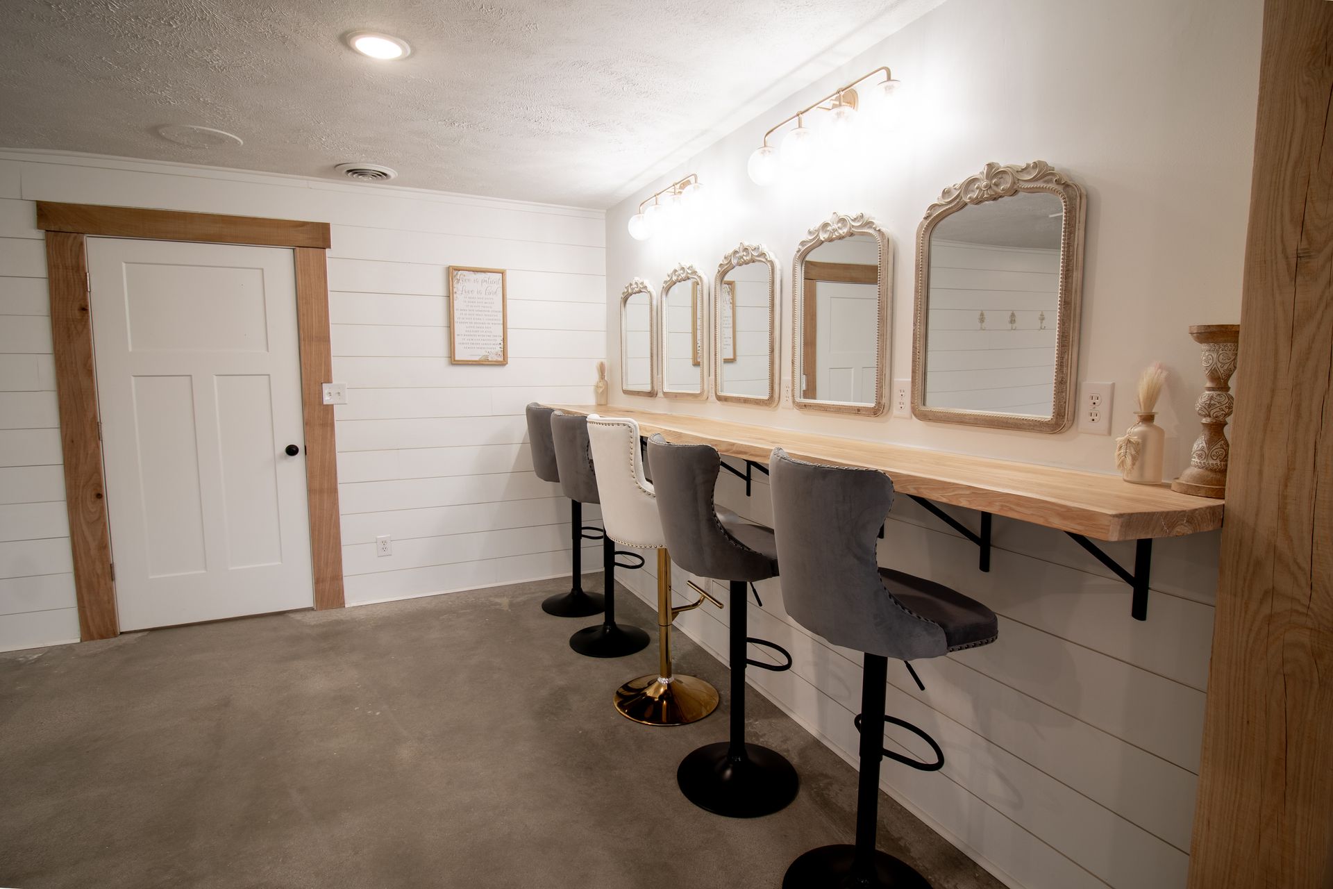 A room with a row of chairs and mirrors on the wall.