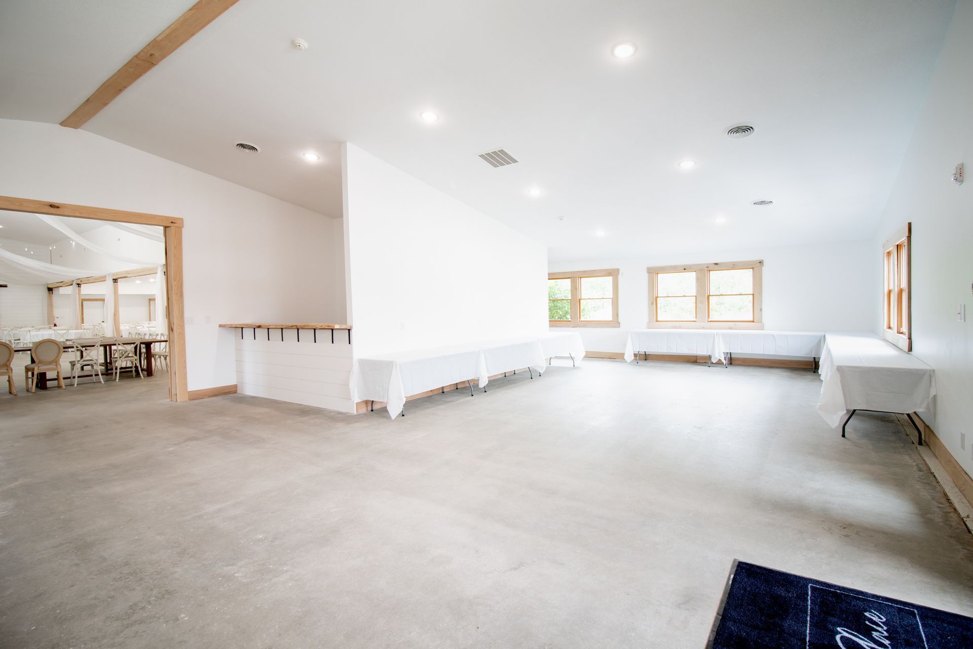 A large empty room with tables and chairs in it.