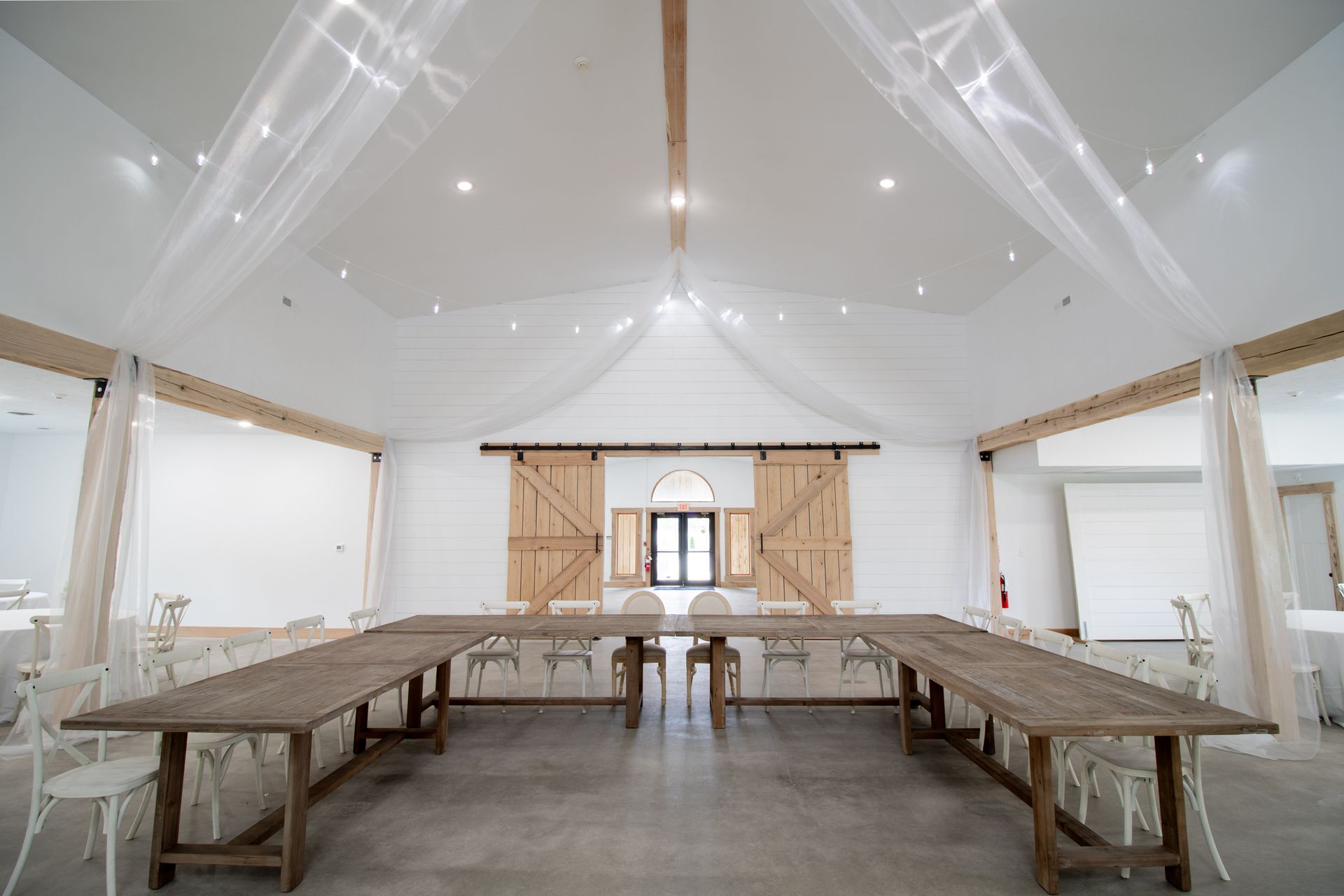 A large room with a long table and chairs in it.