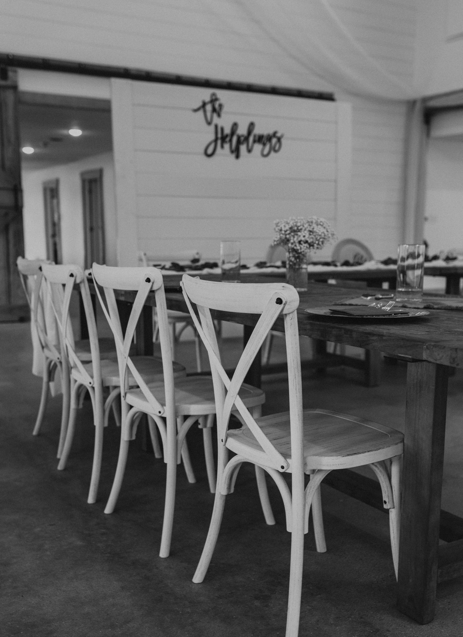 A black and white photo of a dining room with tables and chairs.