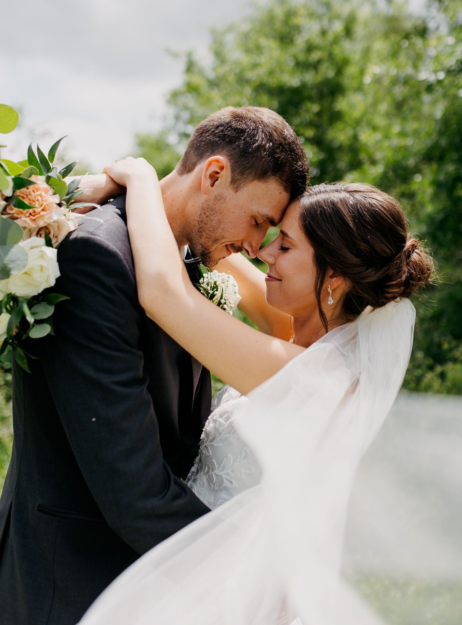 A bride and groom are kissing each other on their wedding day.