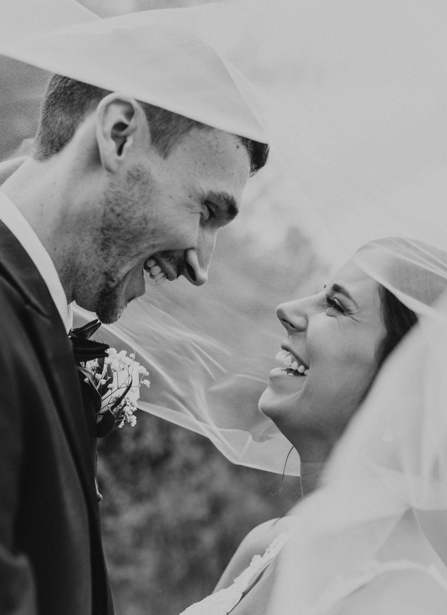 A black and white photo of a bride and groom looking at each other.