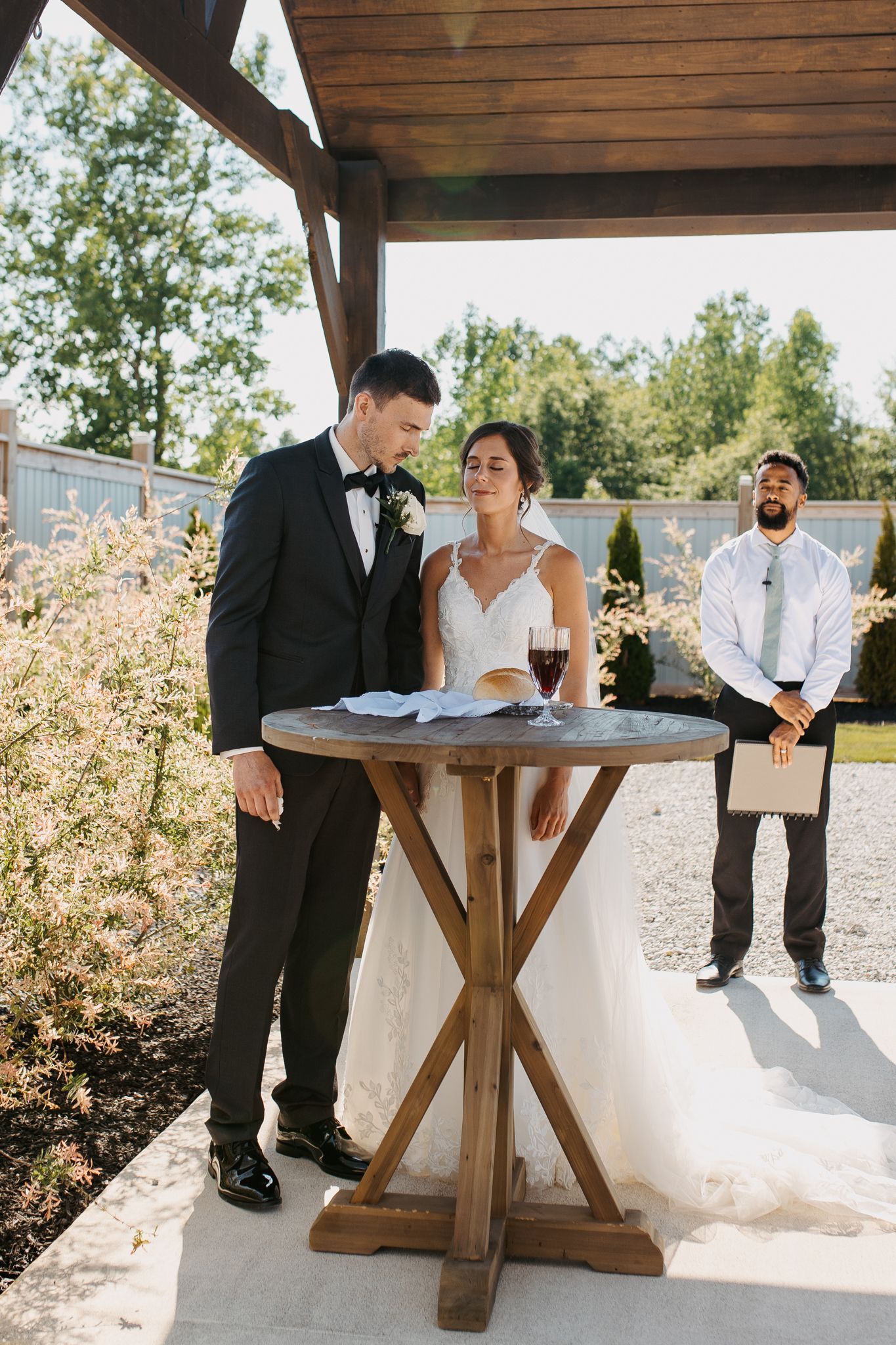 A bride and groom are sitting at a table during their wedding ceremony.