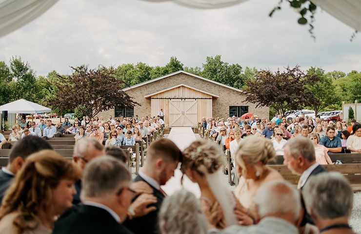 A bride and groom are getting married in front of a crowd of people.