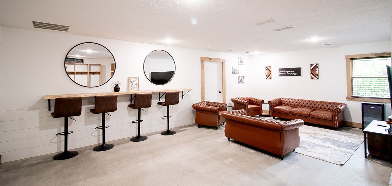A living room with a couch , chairs , and a mirror.