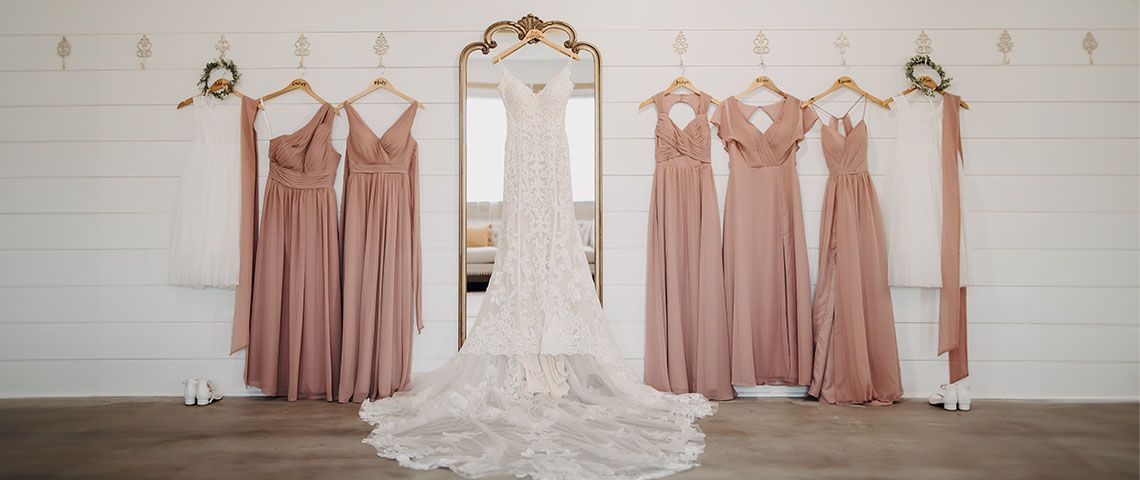 A bride and her bridesmaids are getting ready for their wedding in front of a mirror.