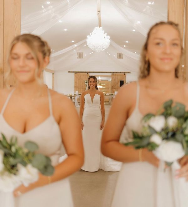 A bride and her bridesmaids are standing in a hallway