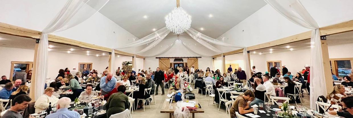 A large group of people are sitting at tables in a large room.