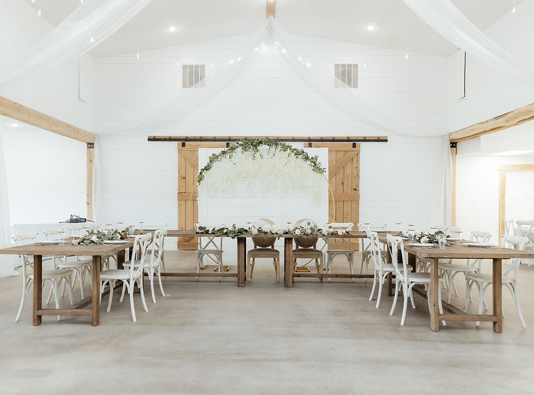 A large room with tables and chairs set up for a wedding reception.