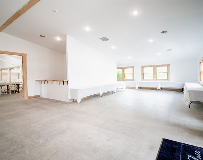 A large empty room with tables and chairs in it.