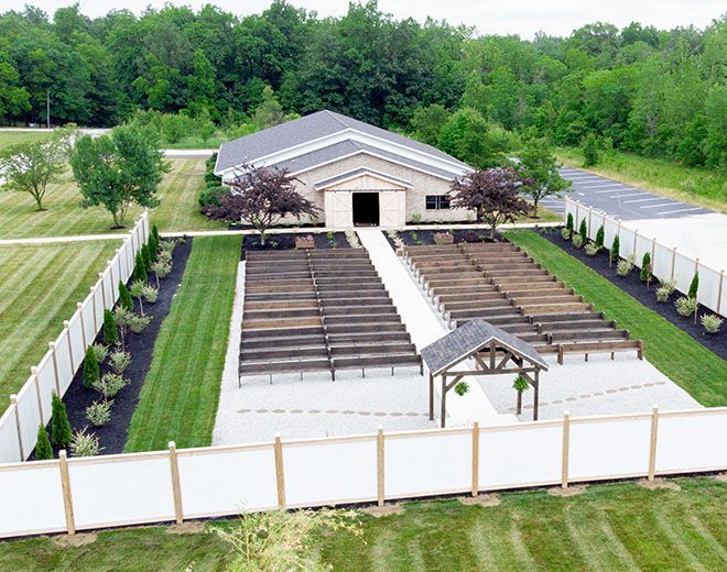 An aerial view of a wedding venue with a white fence around it