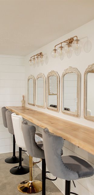 A row of chairs sitting next to each other in a room with mirrors on the wall.