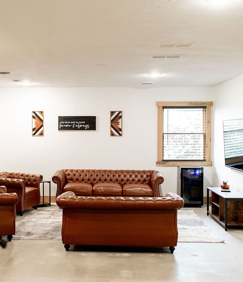 A living room with a brown couch and two chairs