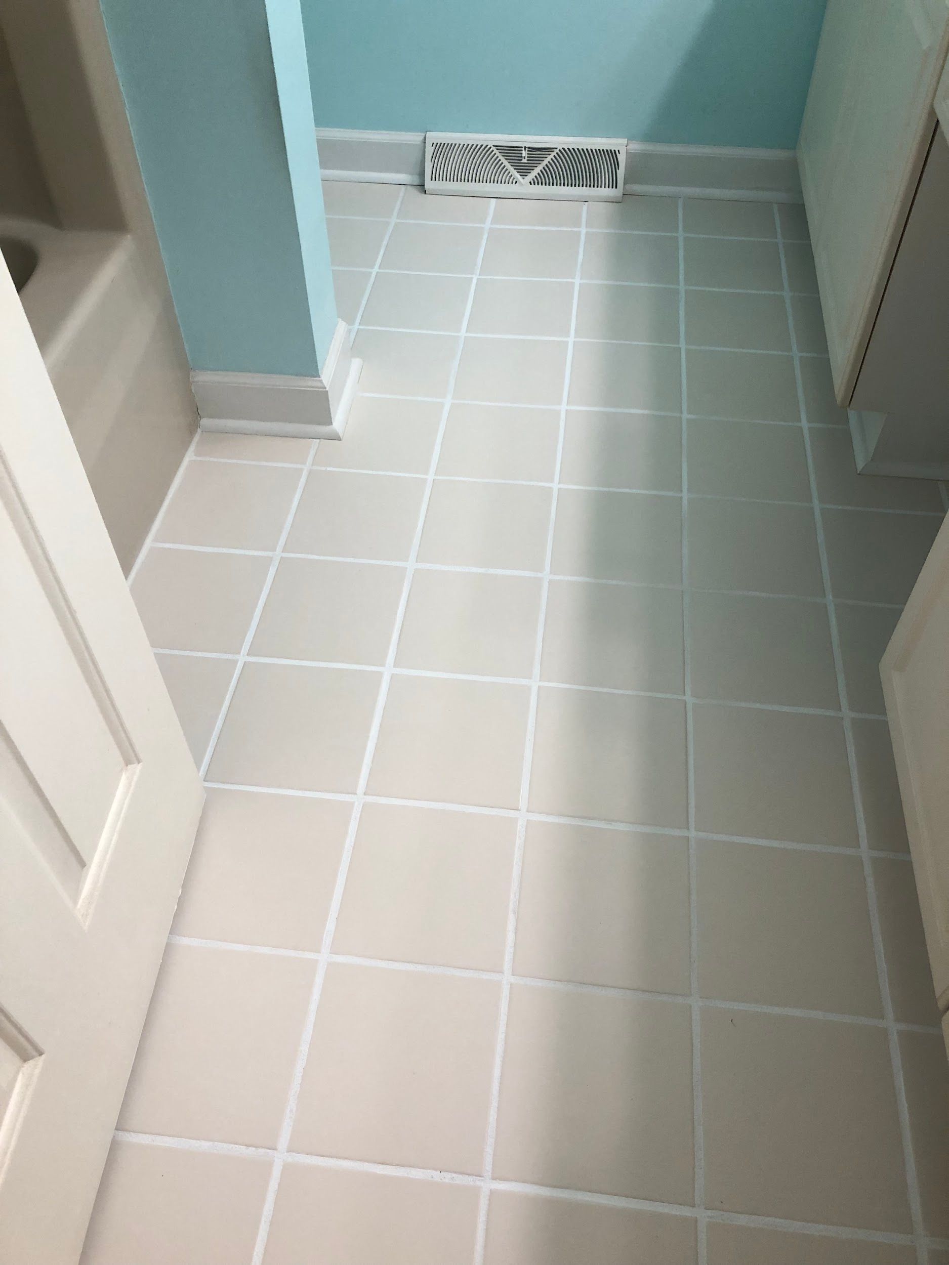 A bathroom with white tile floors and blue walls.